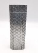 A white metal lighter by Cartier Paris. The lighter of flattened cylindrical form having engine