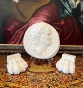 A PLASTER RELIEF OF EMPEROR NERO TOGETHER WITH TWO PLASTER LIONS PAWS