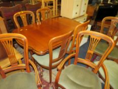 A MODERN EXTENDING DINING TABLE WITH EIGHT CHAIRS
