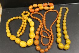A COLLECTION OF AMBER AND LUCITE VINTAGE BEADS, comprising three necklaces and one bracelet