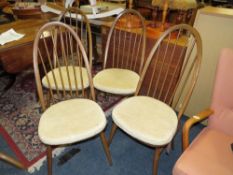 AN ERCOL DINING TABLE WITH FOUR HOOP BACK CHAIRS
