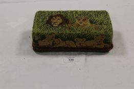 A VINTAGE LION EMBELLISHED EMBROIDERED COVERED STONE DOORSTOP