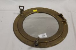 A VINTAGE BRASS PORTHOLE MIRROR
