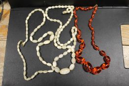 A VINTAGE MOTHER OF PEARL NECKLACE TOGETHER WITH A VINTAGE HAND KNOTTED AMBER TYPE / LUCITE BEAD