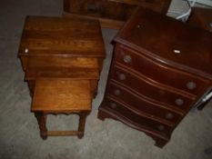 A SMALL SERPENTINE FRONTED 4 DRAWER CHEST AND AN OAK NEST OF TABLES