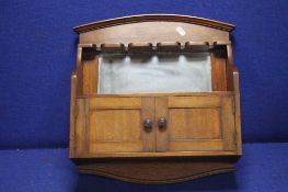 A SMALL MAHOGANY SHELF FITTED WITH PIPE RACK