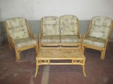 A BAMBOO CANE CONSERVATORY SUITE CONSISTING OF A 2 SEATER SOFA, 2 CHAIRS AND A COFFEE TABLE