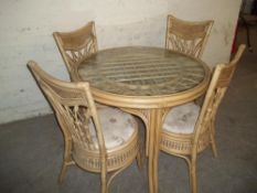 A GLASS TOPPED DINING TABLE WITH 4 CHAIRS