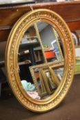 A LARGE OVAL GILT MIRROR 97 CM X 68 CM