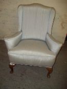 AN ANTIQUE UPHOLSTERED WING BACK CHAIR WITH QUEEN ANNE LEGS