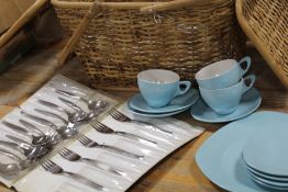 A TWIN HANDLED PICNIC BASKET CONTAINING RETRO MELAMINE PLATES ETC