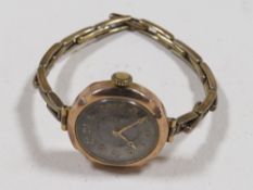 A 9CT GOLD CASED LADIES WATCH ON BASE METAL EXPANDING STRAP