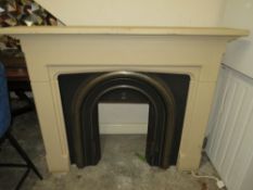 A MODERN CAST IRON FIRE SURROUND WITH A COMPOSITE SURROUND