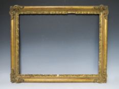 A LATE 18TH / EARLY 19TH CENTURY GOLD FRAME WITH CORNER EMBELLISHMENTS, leaf design to inner edge,
