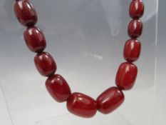 A VINTAGE CHERRY AMBER GRADUATED BEAD NECKLACE, single strand with screw barrel fastening, central