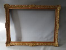 A 19TH CENTURY DECORATIVE GOLD SWEPT FRAME, frame W 6.5 cm, rebate 74 x 54 cm