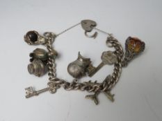 A SILVER CHARM BRACELET, with a small selection of charms attached