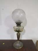 A LATE 19TH CENTURY OIL LAMP, the plated base leading to an etched clear glass reservoir, with