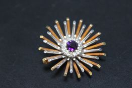 A HALLMARKED WHITE AND YELLOW GOLD DIAMOND AND AMETHYST SET SUNBURST BROOCH, hallmarks indistinct