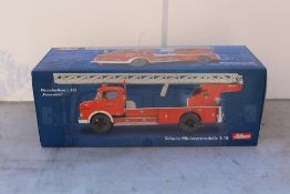 A SCHUCO 1:18 SCALE MERCEDES BENZ L322 MODEL FIRE ENGINE IN RED