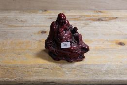 AN ORIENTAL FIGURE OF A SEATED LAUGHING BUDDHA HOLDING A PEACH A/F