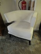 A MODERN UPHOLSTERED CREAM COLOURED ARMCHAIR