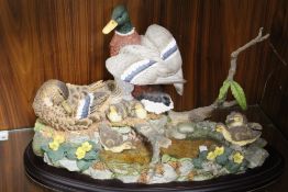 A LARGE AND HEAVY BORDER FINE ARTS STYLE TABLEAU OF DUCKS AND DUCKLINGS BY A POND