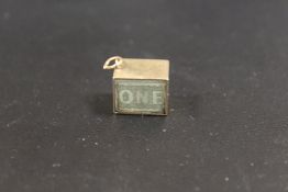 A 9CT GOLD CHARM CONTAINING AN OLD £1 NOTE