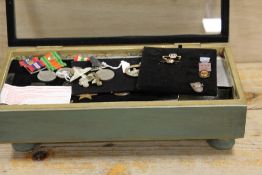 A DISPLAY CASE OF MEDALS AND MILITARY BADGES ETC