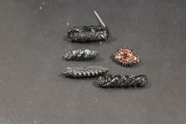 A SMALL SELECTION OF JET TYPE BROOCHES ETC