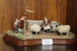 A BORDER FINE ARTS STYLE FIGURE TABLEAU OF A FARMER FEEDING SHEEP AND A BOY POSTING MAIL