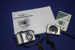 A MINOLTA DIGITAL CAMERA WITH INSTRUCTION MANUAL ALONG WITH A SMALL CANON CAMERA