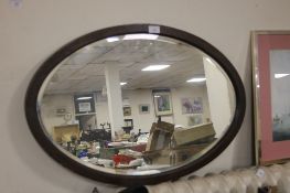 A FRAMED OVAL MIRROR