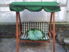 A HARDWOOD OUTDOOR GARDEN SWING AND COVER