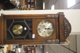 A WOODEN CASED CLOCK WITH KEY