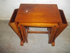 A WALNUT NEST OF 3 TABLES WITH A MAGAZINE RACK
