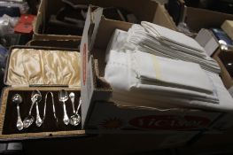 A BOX OF LINEN AND A CASED SET OF EPNS SPOONS