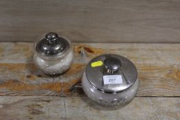 TWO HALLMARKED SILVER TOPPED DRESSING TABLE JARS TO INCLUDE AN ART DECO EXAMPLE