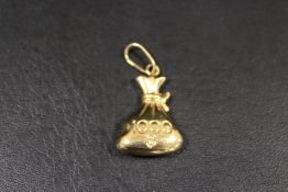 A CONTINENTAL C18 NOVELTY PENDANT IN THE FORM OF A 1000 $ MONEY BAG - APPROX WEIGHT 1.9 G
