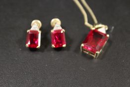 A EMERALD CUT RED STONE HALLMARKED 9CT GOLD PENDANT ON CHAIN STAMPED 375 WITH A MATCHING PAIR OF