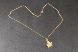 A 10K REMBRANT NIAGRA FALLS MAPLE LEAF PENDANT ON CHAIN STAMPED 9K - APPROX COMBINED WEIGHT 2.6 G