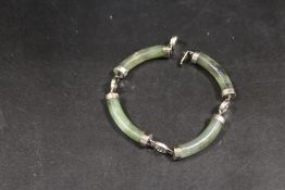 A MODERN FAUX JADE AND WHITE METAL BRACELET WITH ORIENTAL CHARACTER MARK EMBELLISHMENT