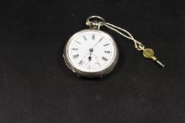 AN ANTIQUE SILVER CASED POCKET WATCH WITH KEY