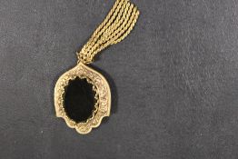 AN UNUSUAL AGATE BROOCH IN FLORAL DECORATED SHIELD MOUNT WITH TASSEL DROPPER