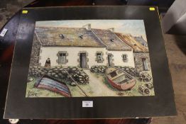 A CLIP FRAMED WATERCOLOUR OF BOATS AND LOBSTER POTS IN FRONT OF A WELSH COTTAGE SIGNED LOWER LEFT