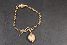 A SMALL 9CT ROSE GOLD BRACELET WITH HEART DROPPER, T-BAR AND ORNATE CENTRAL LINK - APPROX WEIGHT 5.5