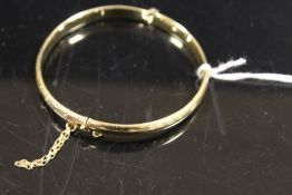 A HALLMARKED 9CT GOLD HINGED BANGLE WITH SAFETY CHAIN - APPROX WEIGHT 7.2 G