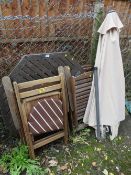 A TEAK PATIO TABLE WITH FOUR CHAIRS AND A PARASOL