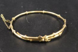 AN ORNATE 9CT GOLD BANGLE WITH SAFETY CHAIN CATCH - APPROX WEIGHT 4.9 G