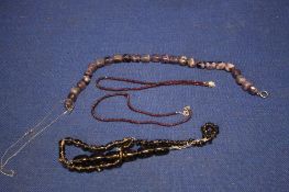 A PLUM COLOURED NECKLACE TOGETHER WITH OTHERS